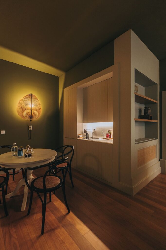 Sala de jantar com mesa redonda e kitchenette integrada em suíte do Torel Saboaria, destaque de design em hotéis boutique no Porto.