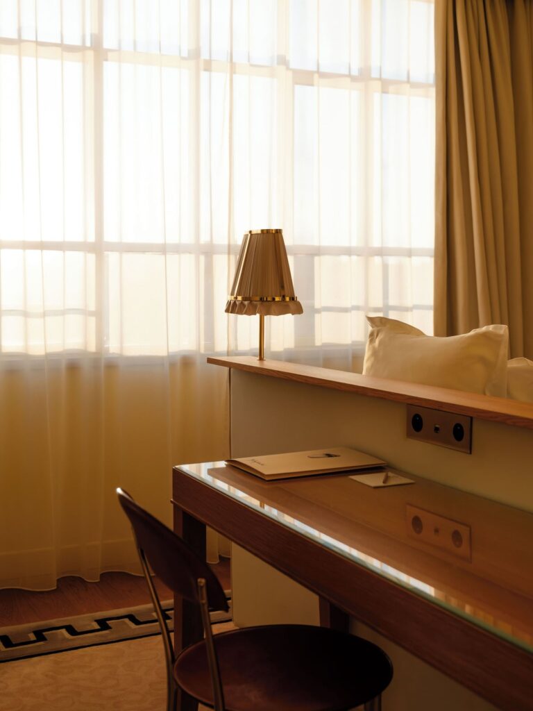 Detalhe da escrivaninha com luminária plissada no 9Hotel Confidential, exemplo do design acolhedor dos hoteis boutique em paris.