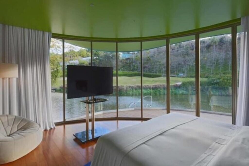Quarto curvo com teto verde e vista para o lago no unique garden de Mairiporã, ícone dos hoteis romanticos em são paulo.