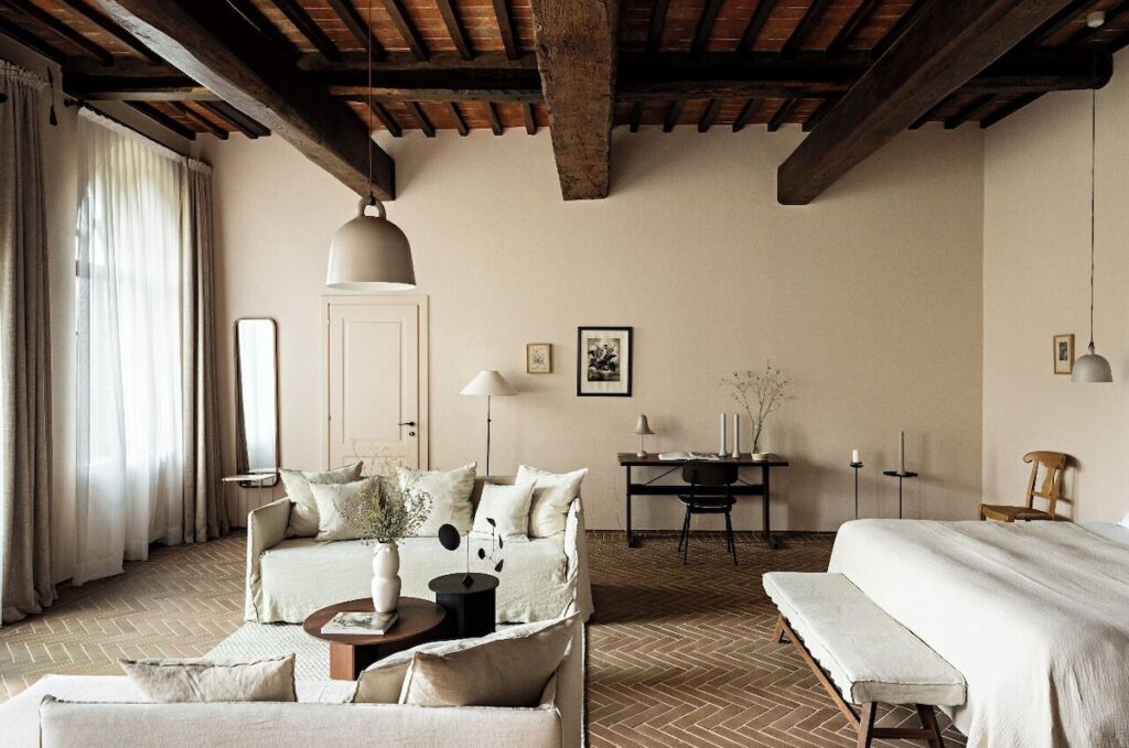 Sala com lareira histórica e afrescos renascentistas no Pieve Aldina, luxo autêntico para lua de mel na europa.