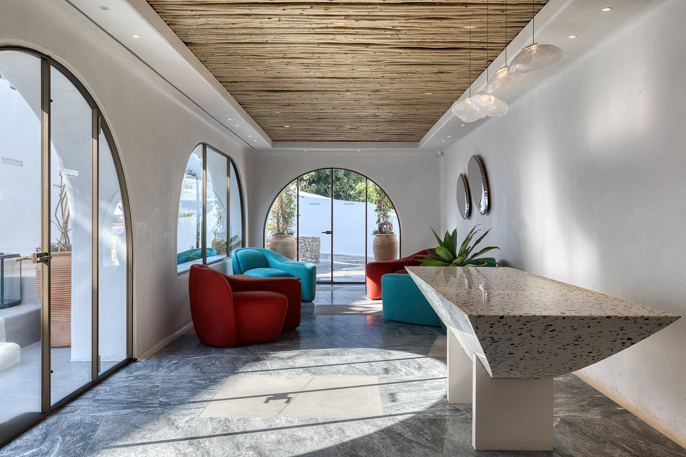 Espreguiçadeira minimalista em deck do Nammos Hotel, moderno resort em Mykonos focado em design sustentável e relaxamento.