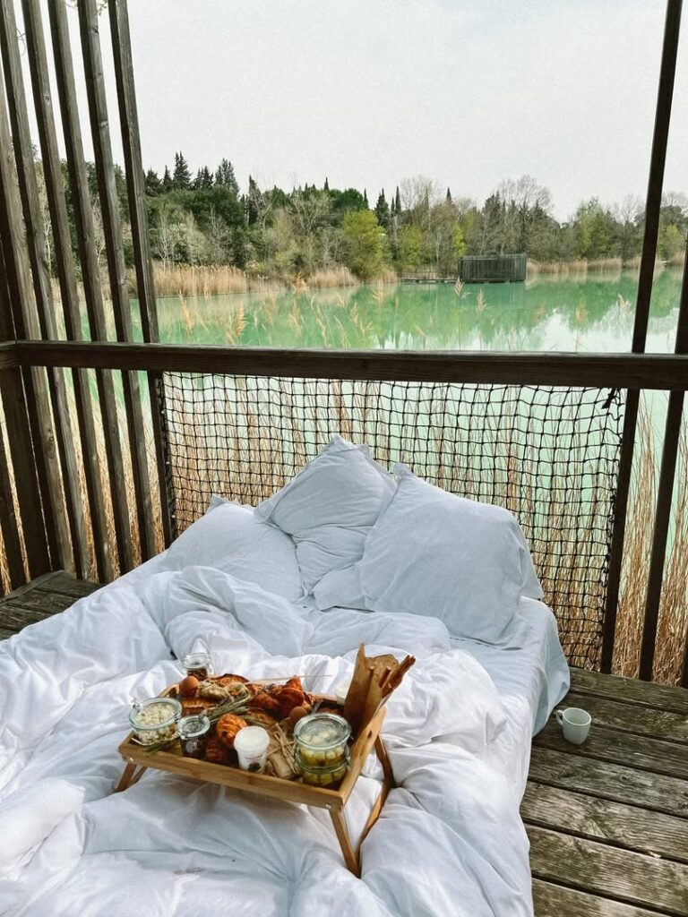Cama ao ar livre com café da manhã no deck de madeira das Cabanes des Grands Cépages, refúgio de lua de mel na europa.