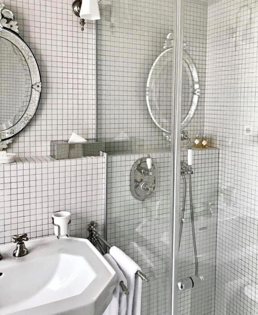 Banheiro retrô no Hôtel Providence -Canal Saint -Martin, ícone dos hoteis boutique em paris, revestido de pastilhas cinza e espelho veneziano clássico.