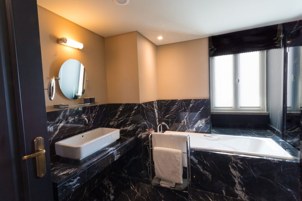 Banheiro luxuoso de mármore preto Nero Marquina no Valverde Hotel, design sofisticado entre os hoteis boutique em lisboa de alto padrão.