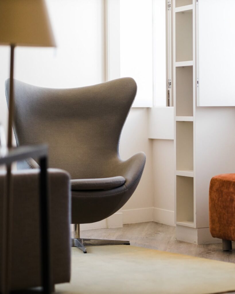 Poltrona Egg cinza no espaço de estar do Memmo Alfama, um dos sofisticados hoteis boutique em lisboa, destacando móveis de design autoral.