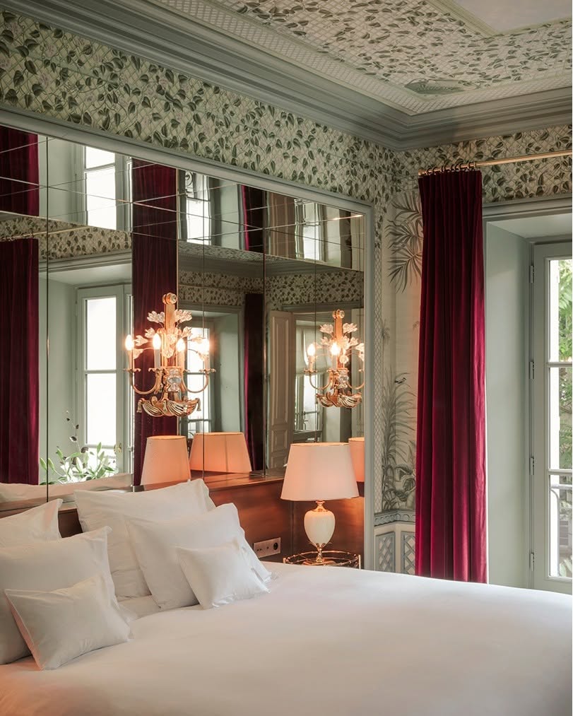 Suíte de luxo com cabeceira espelhada, papel de parede botânico e cortina de veludo no Hôtel Particulier Montmartre, entre os hoteis boutique em paris.