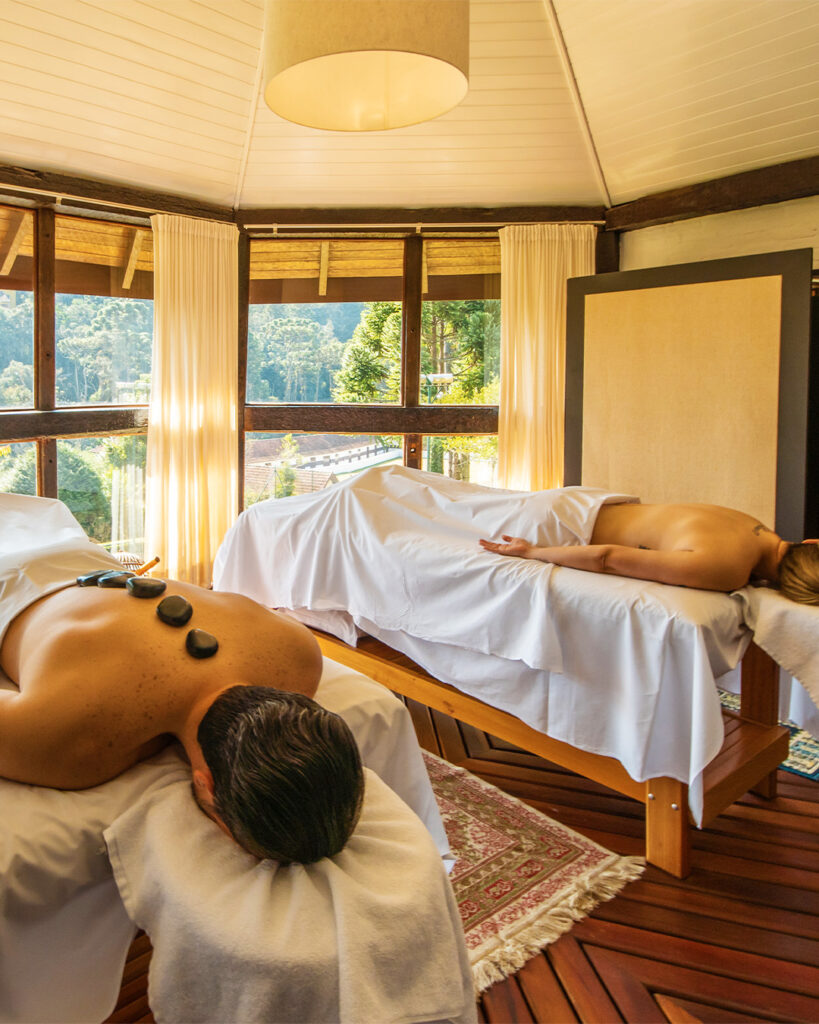 Sala de spa com massagem de pedras quentes para casais em viagem a um dos hotéis românticos em são paulo.