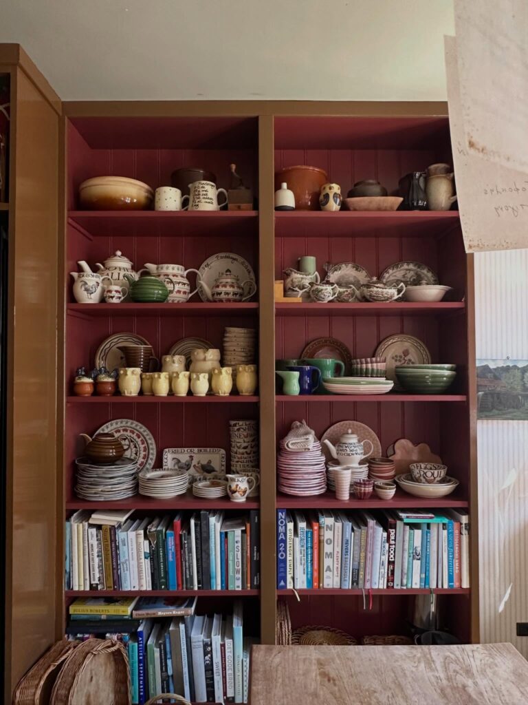 Biblioteca no sótão com poltrona de couro e livros de design no The Monica, cantinho de leitura em lua de mel na europa.