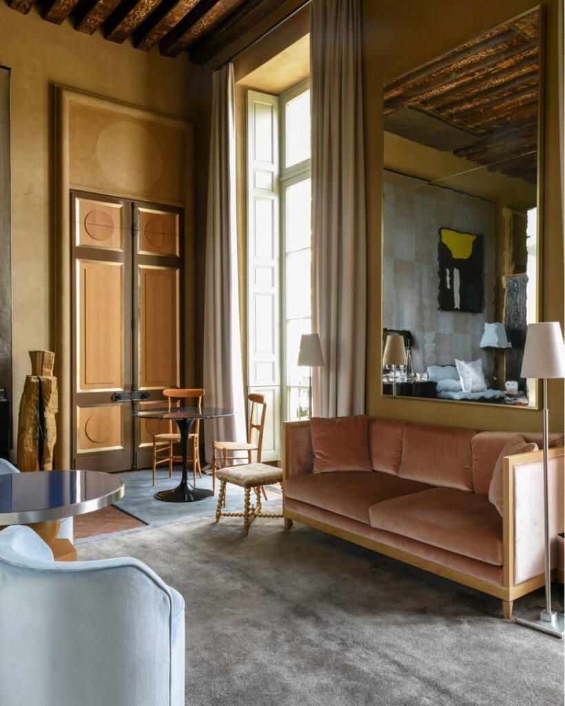 Sala de estar clássica parisienses com teto alto de madeira e móveis de veludo no Cour des Vosges, um dos refinados hoteis boutique em paris.
