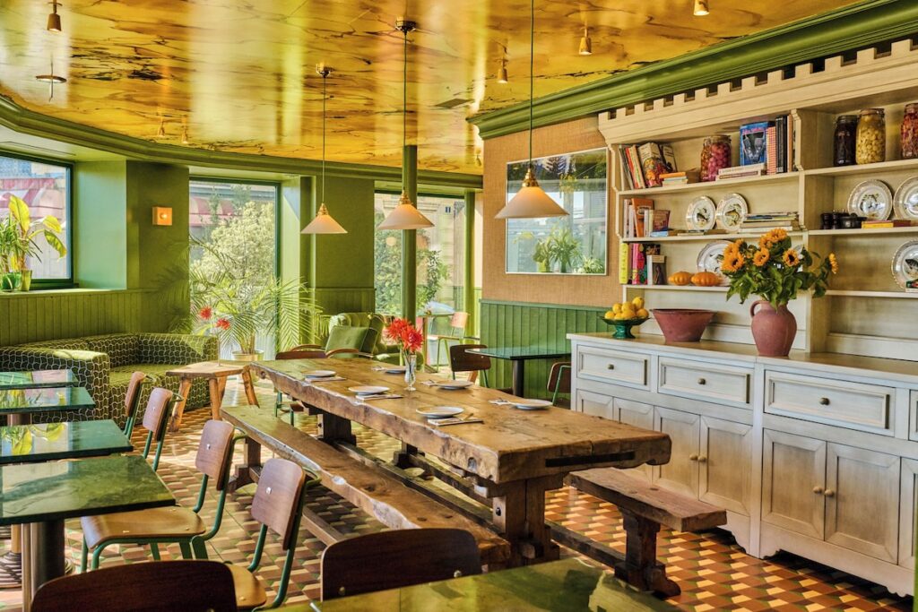 Salão de restaurante bistrô decorado em verde e teto dourado brilhante no Hôtel Les Deux Gares, hotel boutique em paris.
