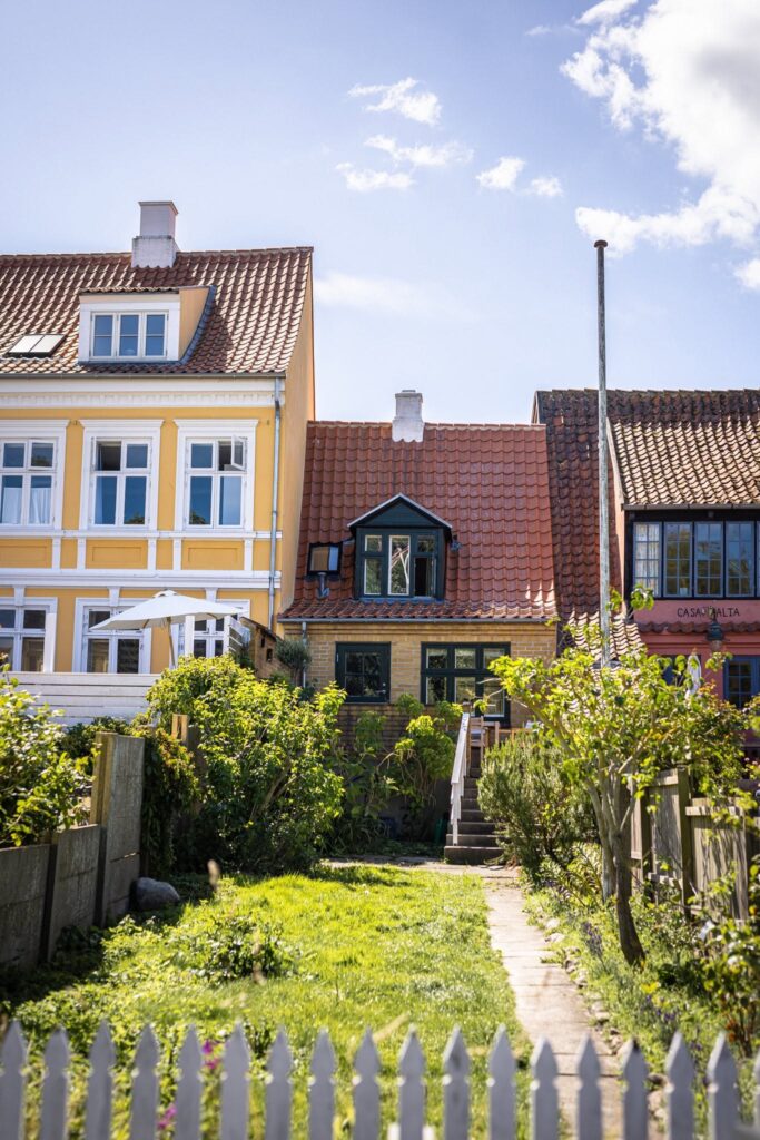 Fachada histórica amarela do Arnfeldt Hotel nas ruelas de pedra de Ærøskøbing, cenário perfeito de lua de mel na europa.