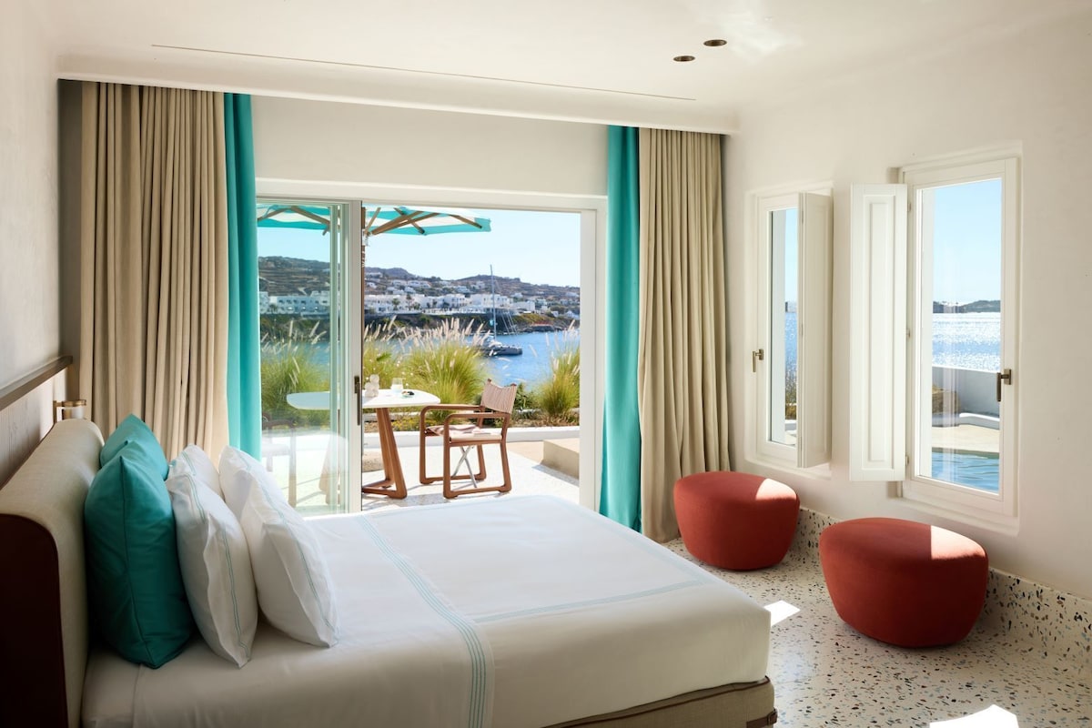 Design de interiores costeiro da Grand Suite com piso de terrazo e toques turquesa e terracota no resort em Mykonos Nammos.