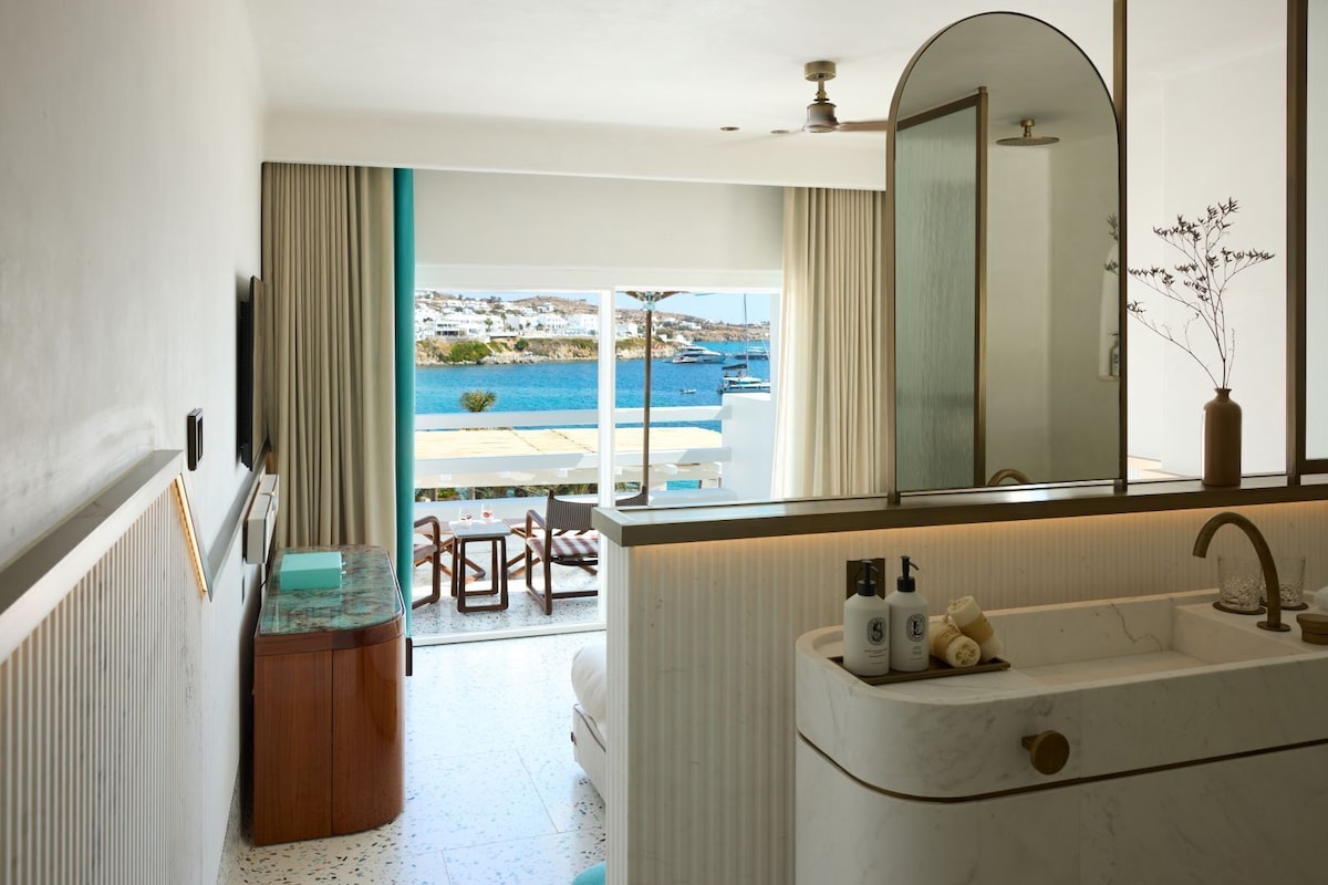 Suíte duplex integrada com bancada de mármore e varanda privativa de frente para a baía de Psarou neste resort em Mykonos.
