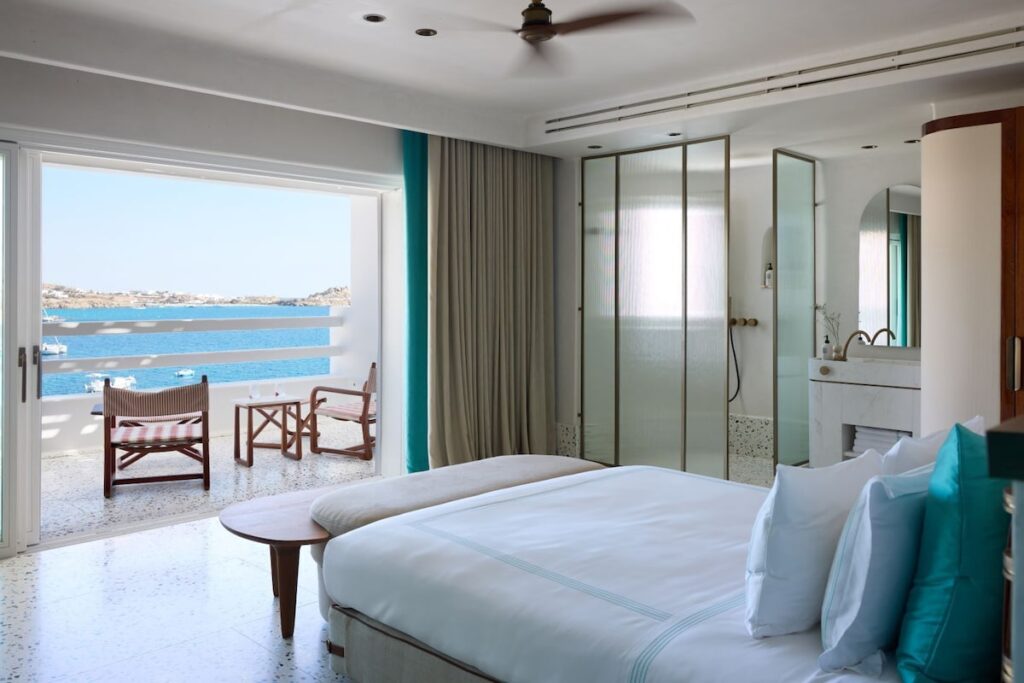 Quarto Premium com cabeceira de palha natural e enxoval da Loro Piana no Nammos Hotel, resort em Mykonos.