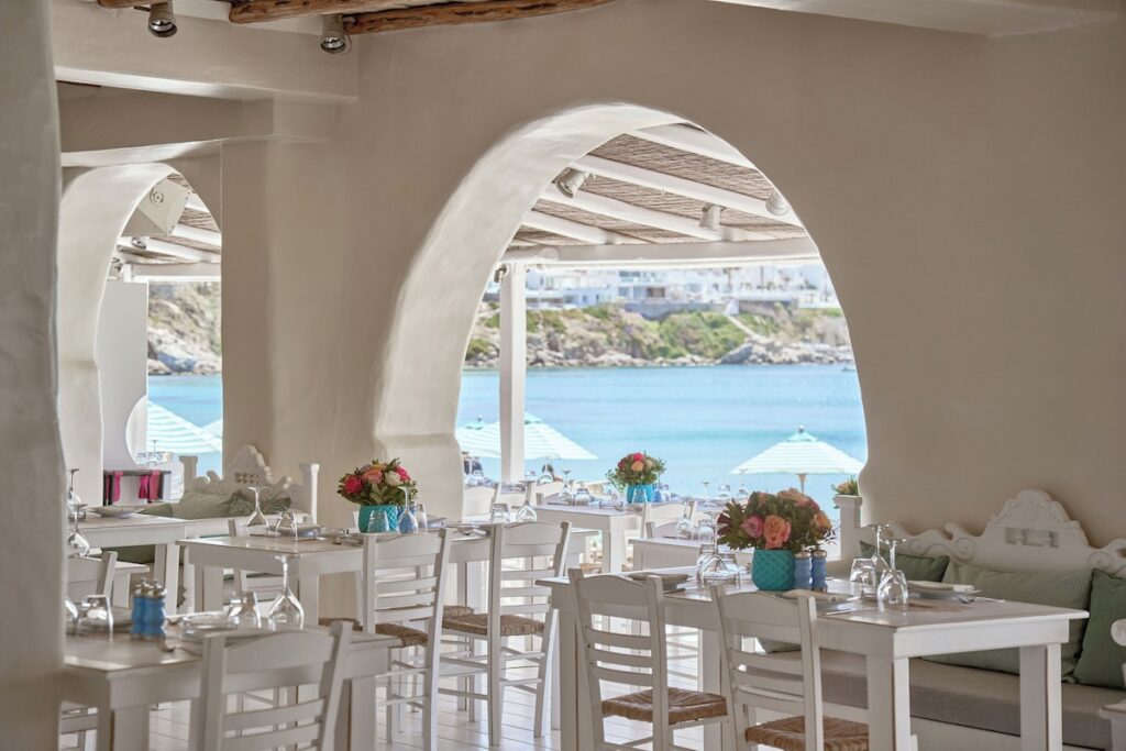 Salão de jantar do NAMMOS Restaurant com arcos gregos e vista para o mar de Psarou no badalado resort em Mykonos.