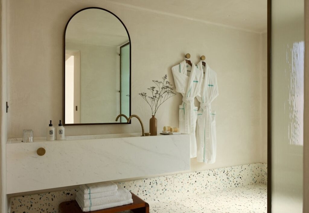 Banheiro contemporâneo com bancada de mármore grego cinza no Nammos Hotel, resort em Mykonos de alto padrão.