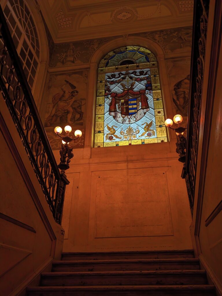 Escadaria interna com vitral histórico no Chiado, um dos bairros mais charmosos indicados para quem busca onde ficar em lisboa.