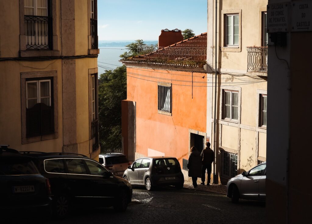 Calçada típica de Alfama com vista para o Rio Tejo, bairro repleto de história ideal para quem busca onde ficar em lisboa.