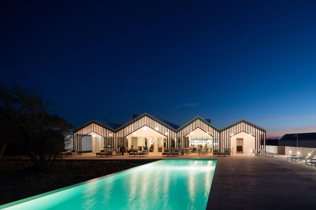 Piscina iluminada e bangalôs modernos do Sobreiras Alentejo Country Hotel na melhor época para visitar portugal.
