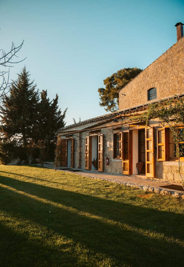 Fachada de pedra da Masseria Susafa, que desponta entre os mais belos hotéis boutique na sicilia sob a luz dourada.