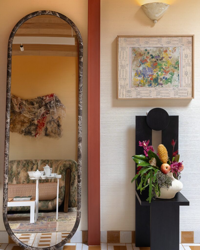 Espelho oval de mármore e pedestal com arranjo floral no projeto Casa EcoMorada por Volar Interiores na CasaCor 2026.