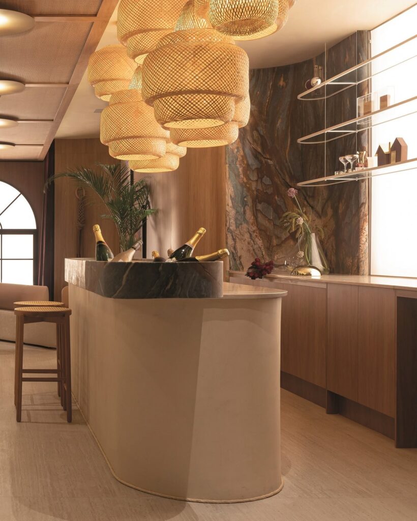 Balcão curvilíneo e pendentes de palha trançada no bar do Qalb Boutique Café por Teresa Simões Arquitetura na CasaCor 2026.