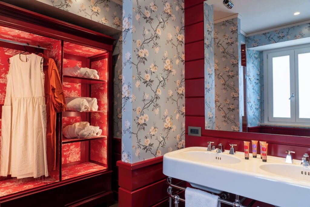 Banheiro luxuoso do Q92 Noto, referência de design e estilo entre os hotéis boutique na sicilia, com armário laqueado vermelho.