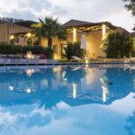 Piscina do Relais San Giuliano, uma refer&ecirc;ncia de lazer entre os hot&eacute;is boutique na sicilia, refletindo o crep&uacute;sculo.