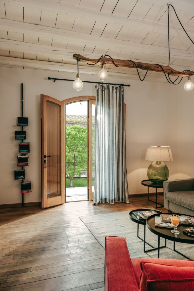 Lounge rústico da Masseria Susafa, integrando a curadoria de hotéis boutique na sicilia, com luminária de galho natural.