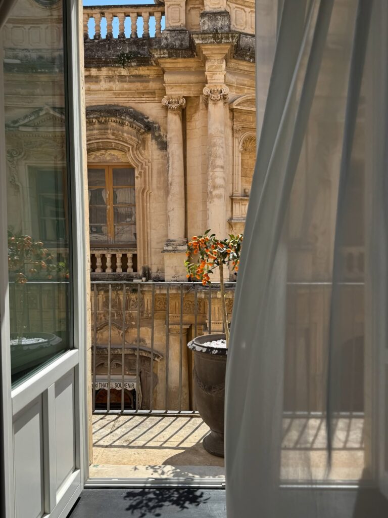 Vista da sacada no Q92 Noto, destacando o melhor da arquitetura nos hotéis boutique na sicilia através de palazzo barroco.