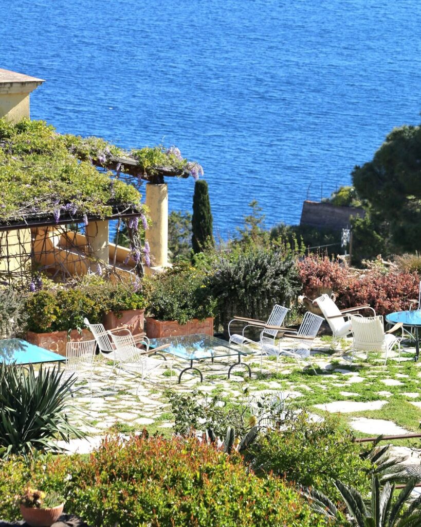 Terraço com glicínias do Hotel Signum Salina, marcando a experiência de se hospedar em hotéis boutique na sicilia.