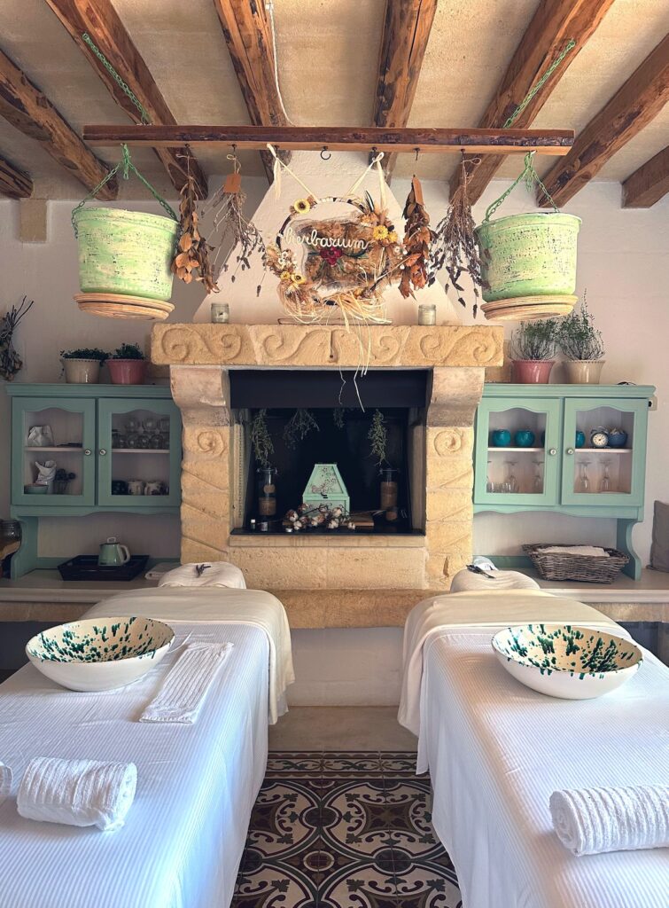 Sala de spa no Herbarium da Masseria Montenapoleone com lareira de pedra e decoração rústica.