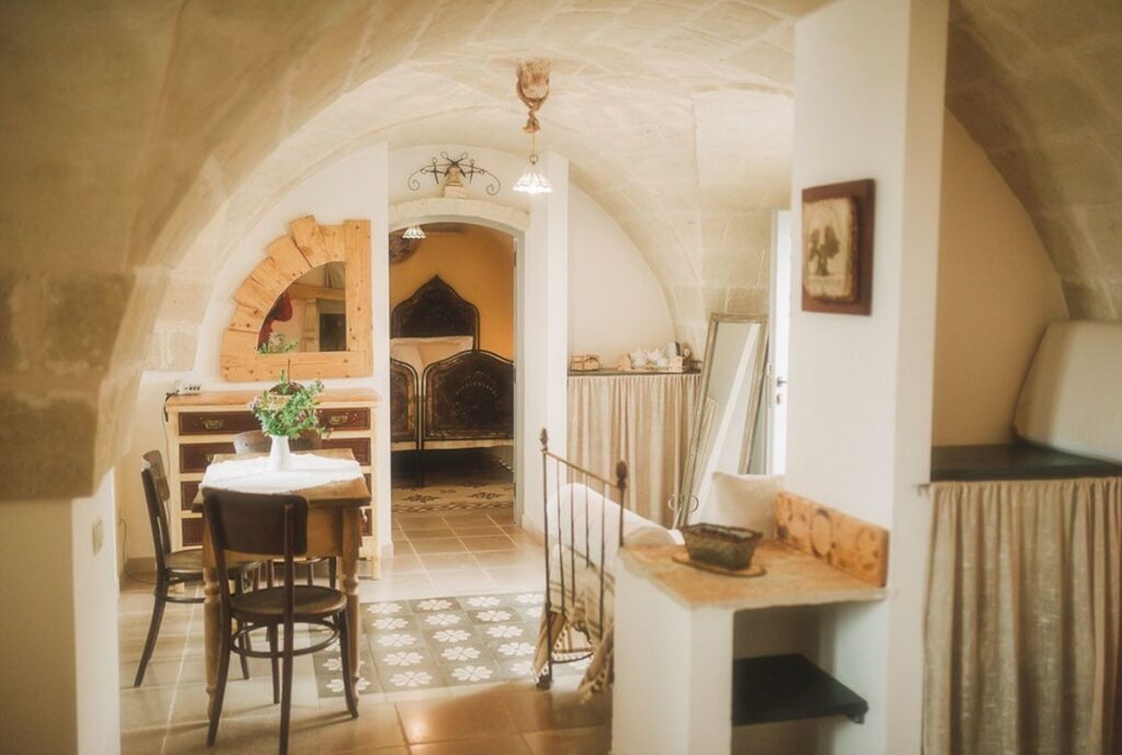 Suíte superior abobadada com piso decorado e móveis de demolição na Masseria Montenapoleone.