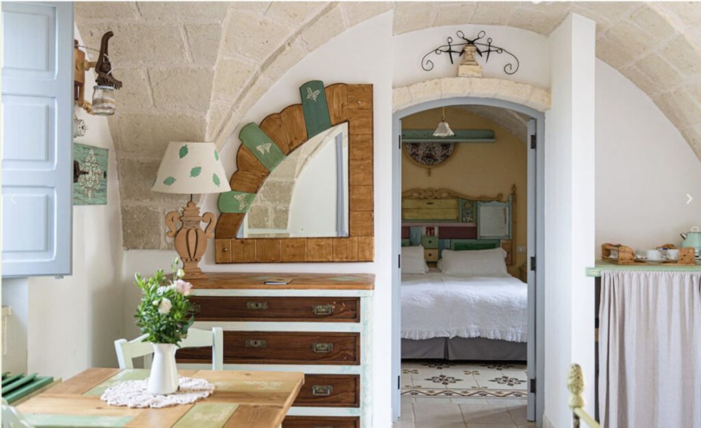 Quarto de família na Masseria Montenapoleone com abóbada de tufo e cabeceira colorida.