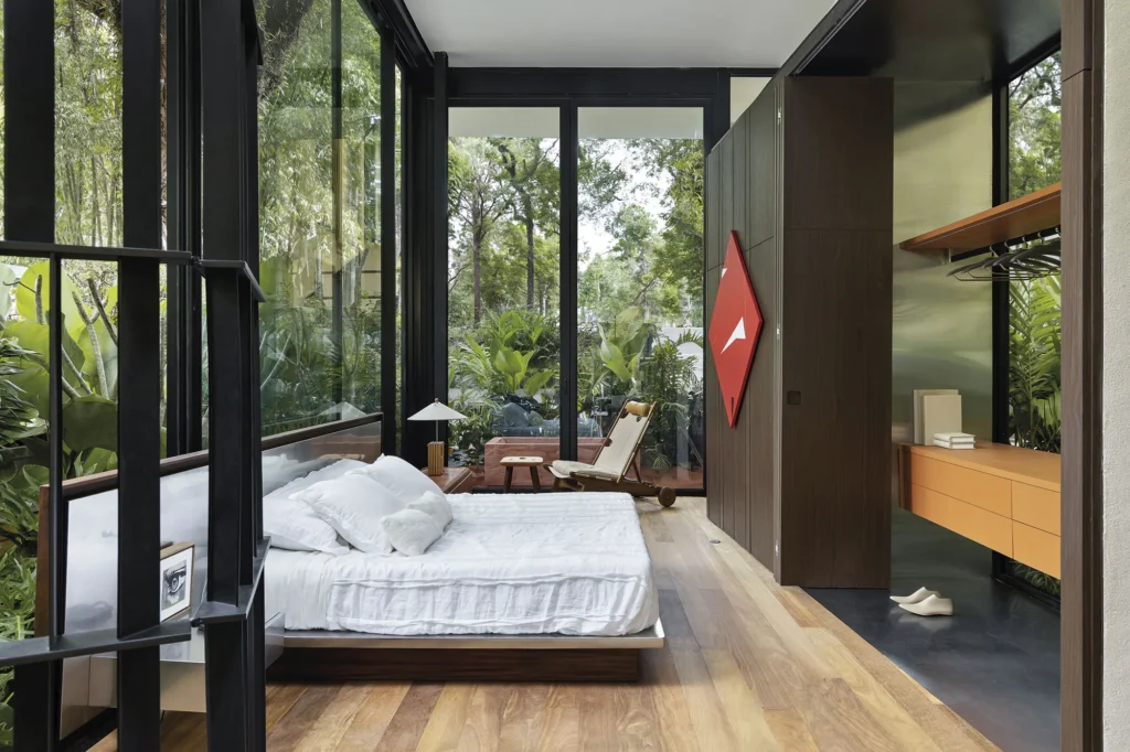 Suíte integrada à natureza com paredes de vidro no projeto Casa Limiar Casacor 2026, por Felipe Rossi Arquitetura.