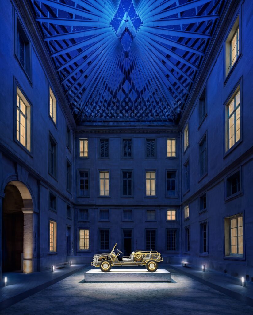 Instalação no pátio interno do Hotel de La Marine no Design Week 2026 com iluminação cênica azul e escultura dourada.