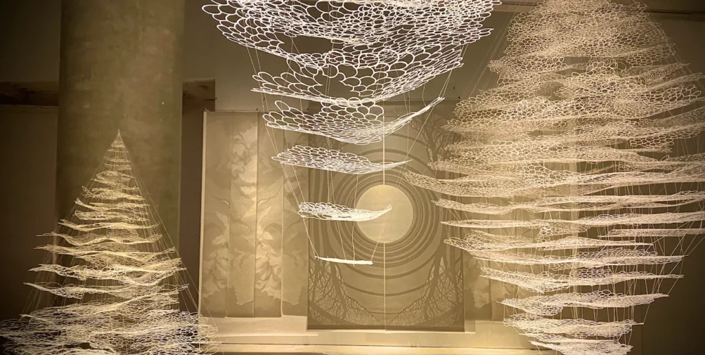 Esculturas de papel rendado flutuantes na Japan House, uma das exposições em São Paulo imperdíveis sobre estética minimalista e nuances de branco.