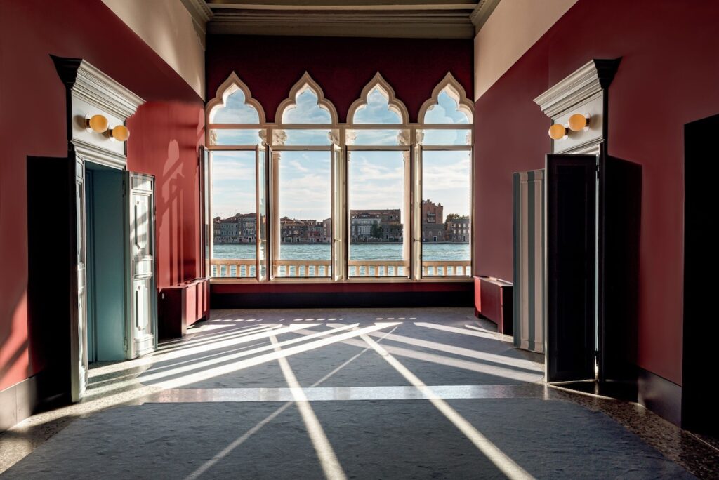 Salão com arcos góticos e vista para a Giudecca no Il Palazzo Experimental, design único nos hotéis de Veneza.