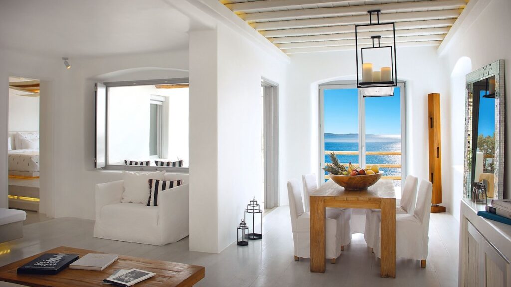 Sala de jantar e estar com vista panorâmica para o mar no Cavo Tagoo, opção exclusiva de onde ficar em Mykonos.