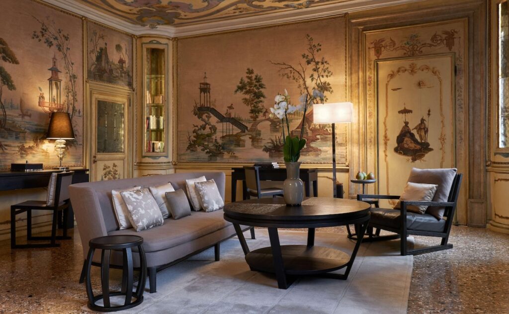 Salão histórico do Aman Venice com afrescos chinoiserie e piso em terrazzo, tradição dos hotéis de Veneza.