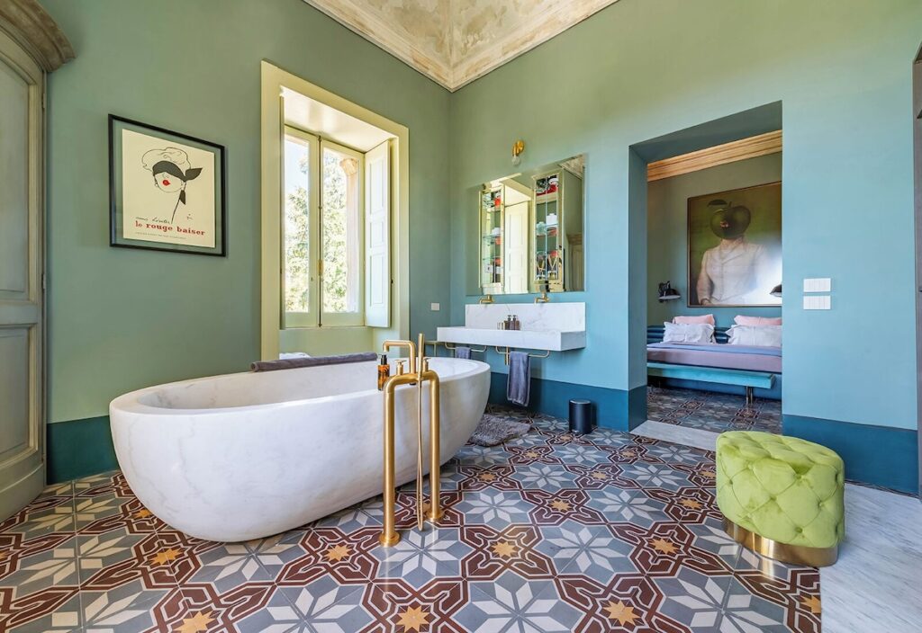 Banheiro integrado com banheira de mármore e piso em cementine no Castle Elvira, sofisticação em hotéis boutique na Púglia.