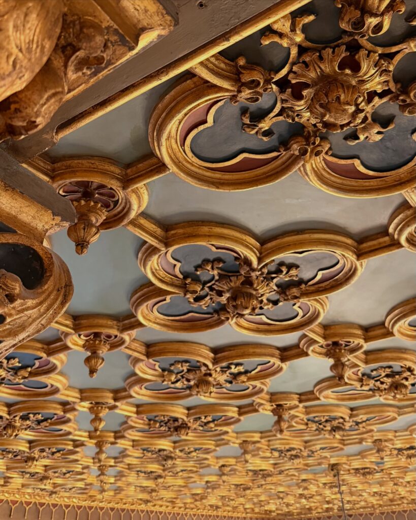 Teto em caixotão ricamente esculpido em talha dourada no Hotel Danieli, revelando a arte palaciana dos hotéis de Veneza.