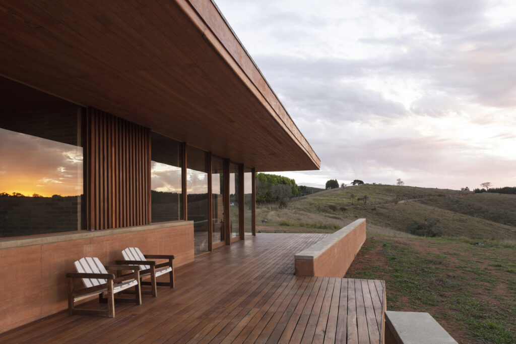 Deck de madeira e paredes de taipa de pilão na Casa em Cunha, exemplo de arquitetura vernacular contemporânea na serra.