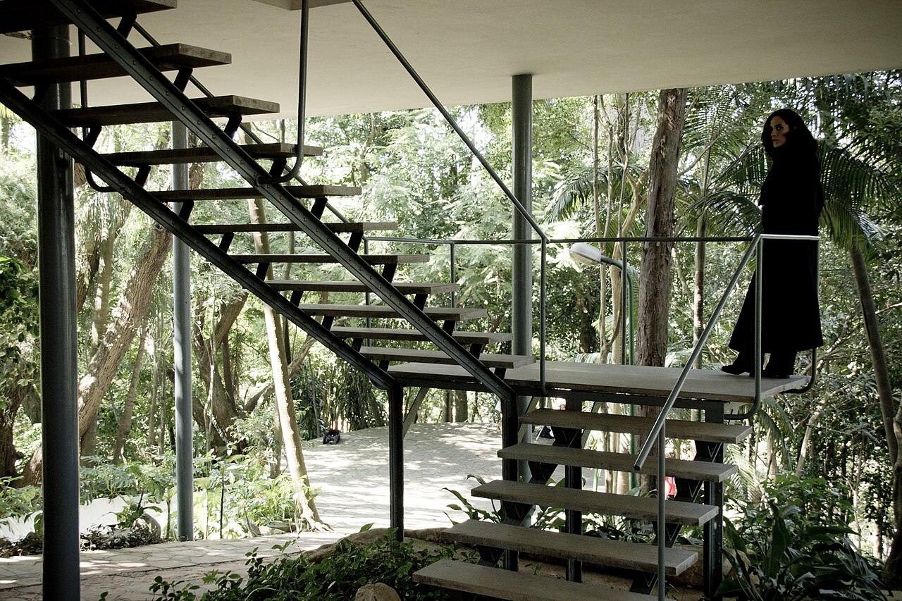 Escadaria metálica suspensa e pilotis na Casa de Vidro, obra modernista icônica de Lina Bo Bardi em São Paulo.