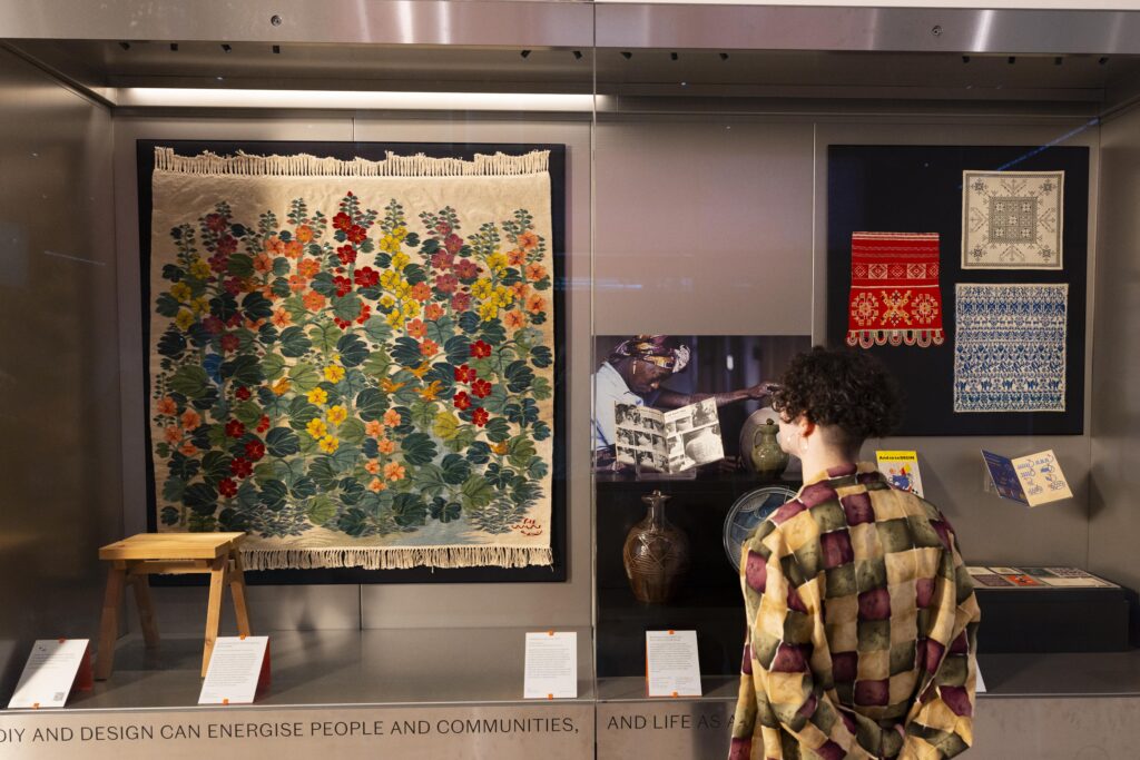 Vitrine com tapeçaria e artesanato no V&A East Museum London na inauguração de museus em 2026.