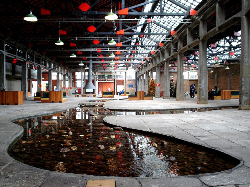 Espelho d'água orgânico e estrutura industrial no SESC Pompeia, projeto emblemático de Lina Bo Bardi em São Paulo.