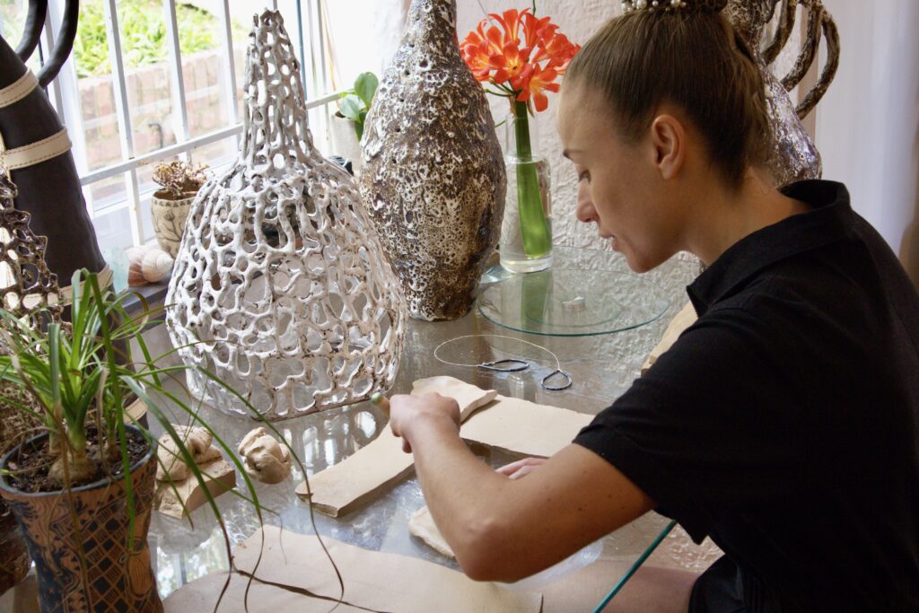 Designer Karlien van Rooyen esculpindo vaso cerâmico vazado para o setor Fine Craft da Maison e Objet.