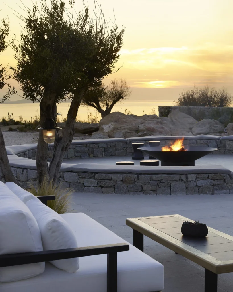Área externa moderna com sofá branco e lareira no Restaurante Noema, Mykonos