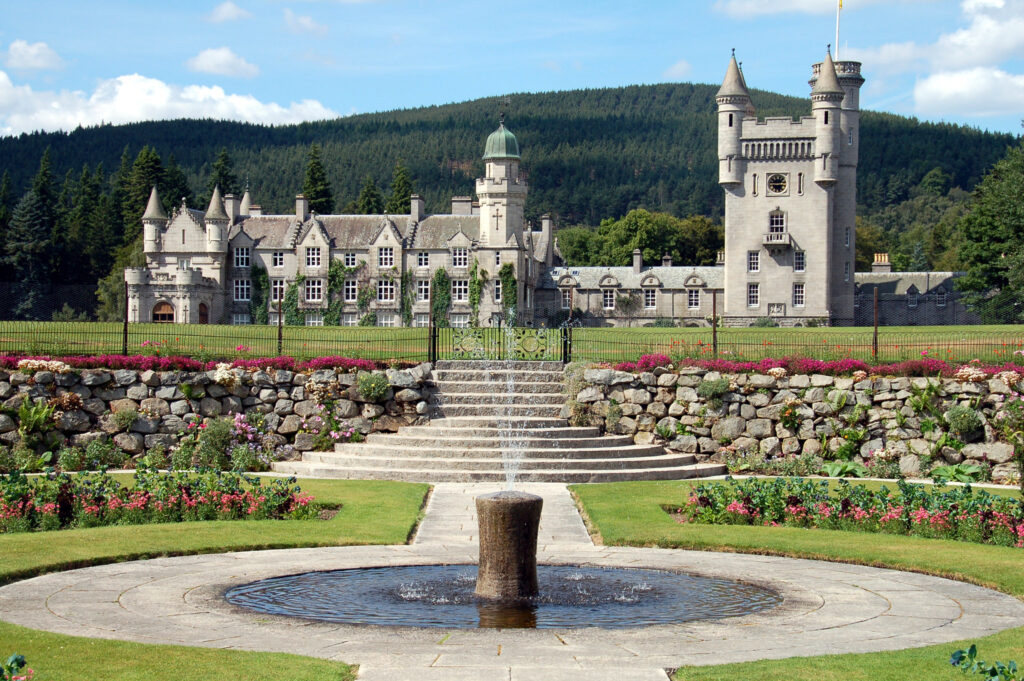Castelo de Balmoral em estilo baronial com torreões e jardins, ápice da arquitetura escocesa vitoriana.