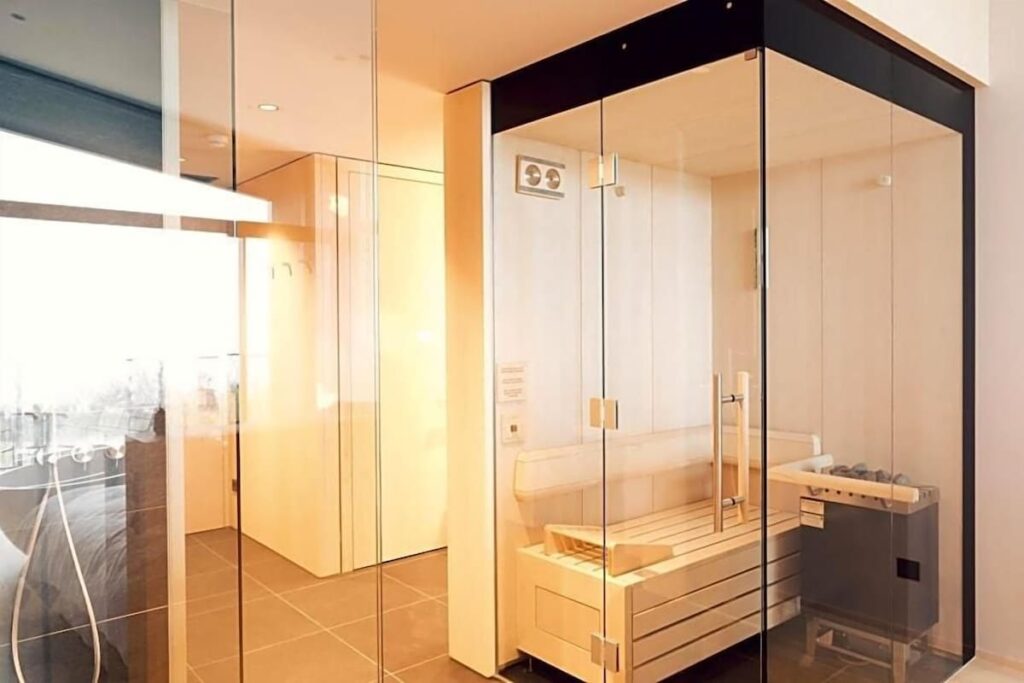 Sauna envidraçada integrada à suíte do Hotel Milla Montis em Maranza, destaque em bem-estar nos hotéis de luxo nos Alpes.